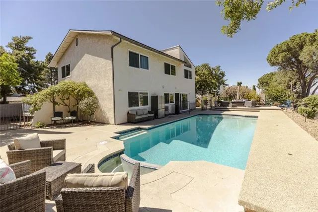 a view of a swimming pool with couches and lounge chairs