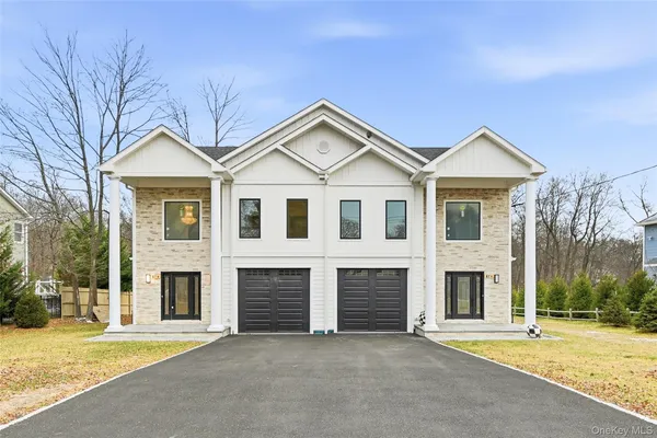 a view of a house with a yard and large tree