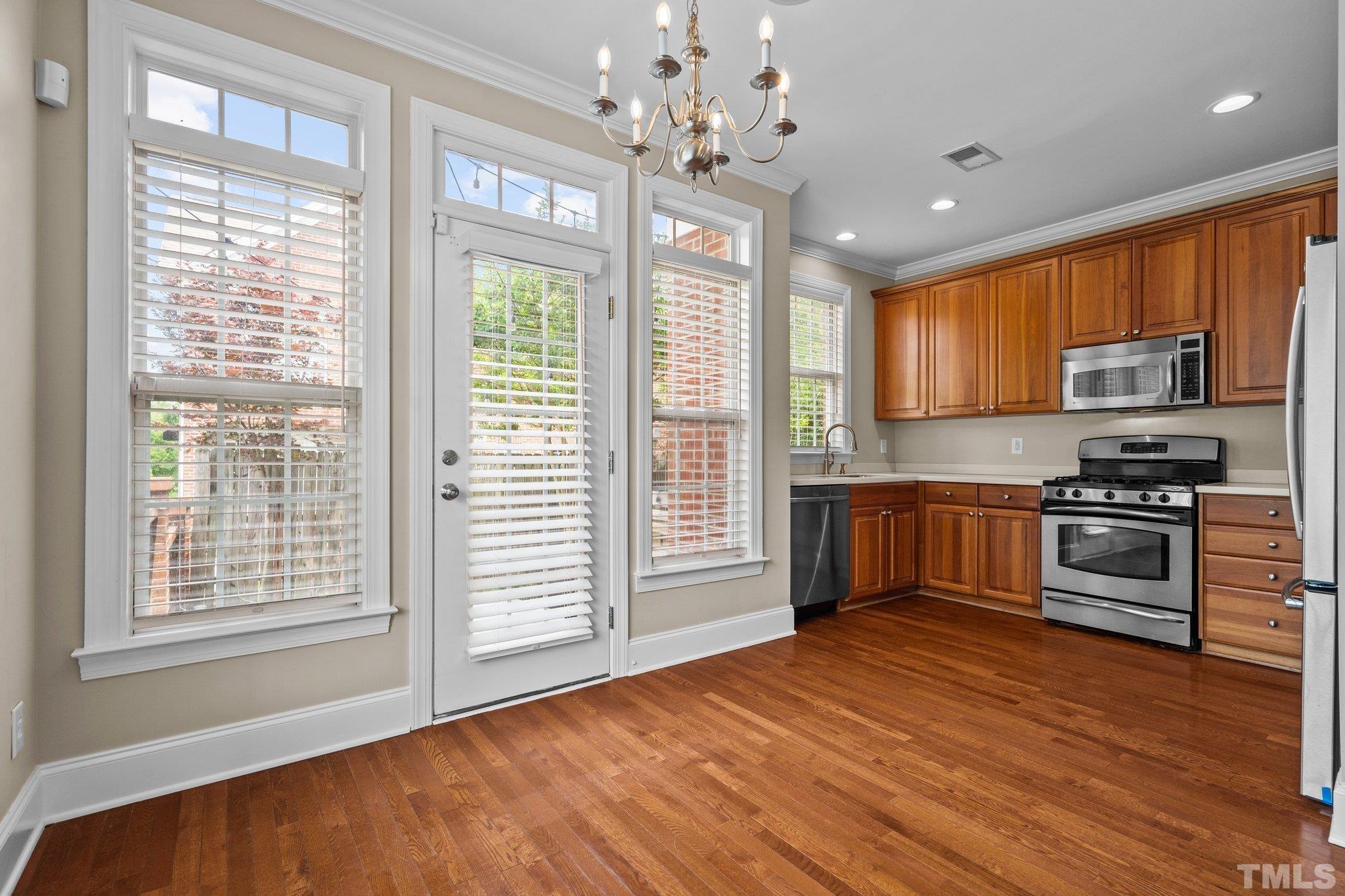 680 Highpark Lane Raleigh, NC 27608 - Photo 8 of 31 a kitchen with granite countertop wooden floors stainless steel appliances and window