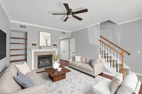 a view of an empty room with wooden floor fireplace and a window