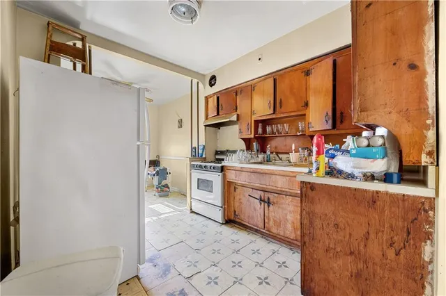 a kitchen with stainless steel appliances granite countertop a refrigerator and a stove top oven