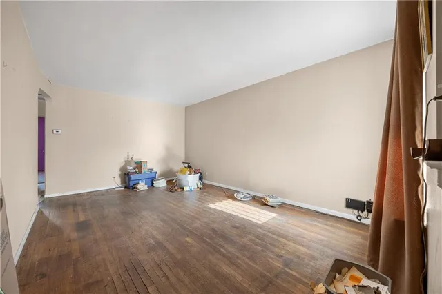 an empty room with wooden floor and bench