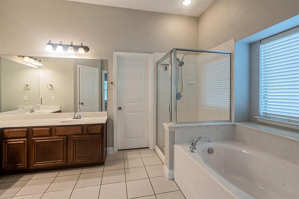 4433 Paula Ridge Court Fort Worth, TX 76137 - Photo 13 of 24 a bathroom with a tub a sink shower and mirror