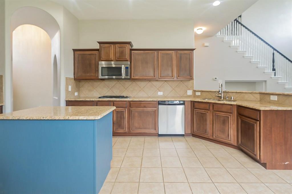 4433 Paula Ridge Court Fort Worth, TX 76137 - Photo 3 of 24 a kitchen with stainless steel appliances granite countertop a stove a sink and a microwave