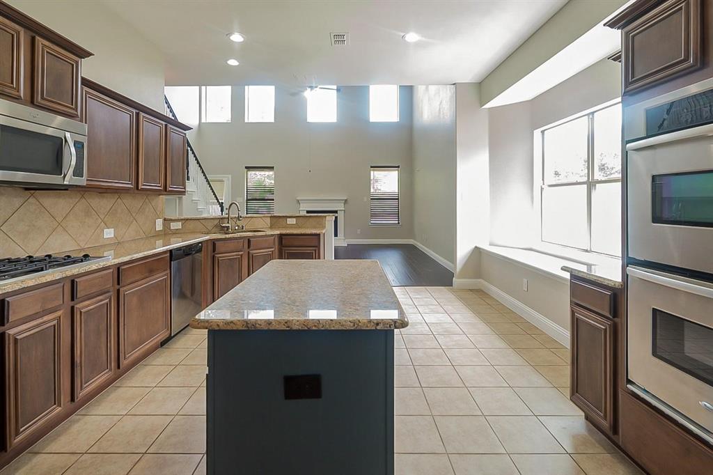 4433 Paula Ridge Court Fort Worth, TX 76137 - Photo 5 of 24 a kitchen with stainless steel appliances granite countertop a stove a sink and a microwave