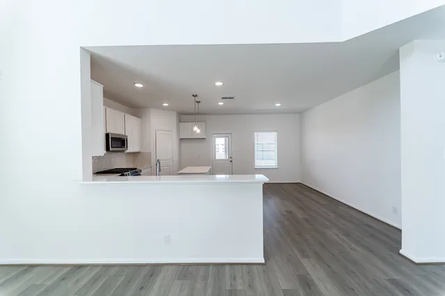 a view of kitchen with kitchen island microwave and wooden floor