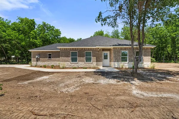 a front view of a house with a garden and patio