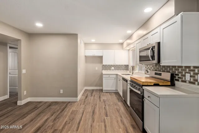 a kitchen with stainless steel appliances granite countertop a stove a sink and a refrigerator