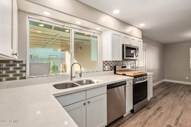 a kitchen with stainless steel appliances granite countertop a sink and a stove