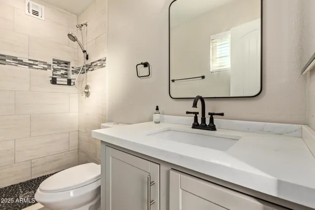 a bathroom with a sink a toilet and shower