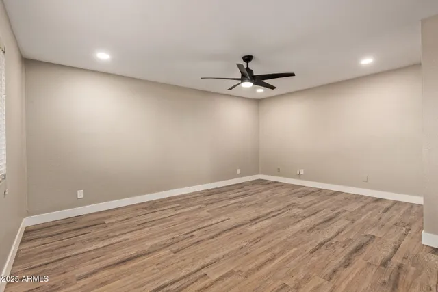 a view of room with wooden floor and ceiling fan
