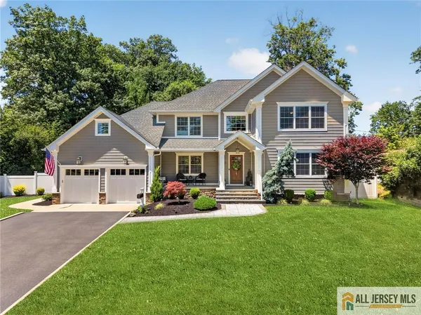 a front view of a house with a yard and trees