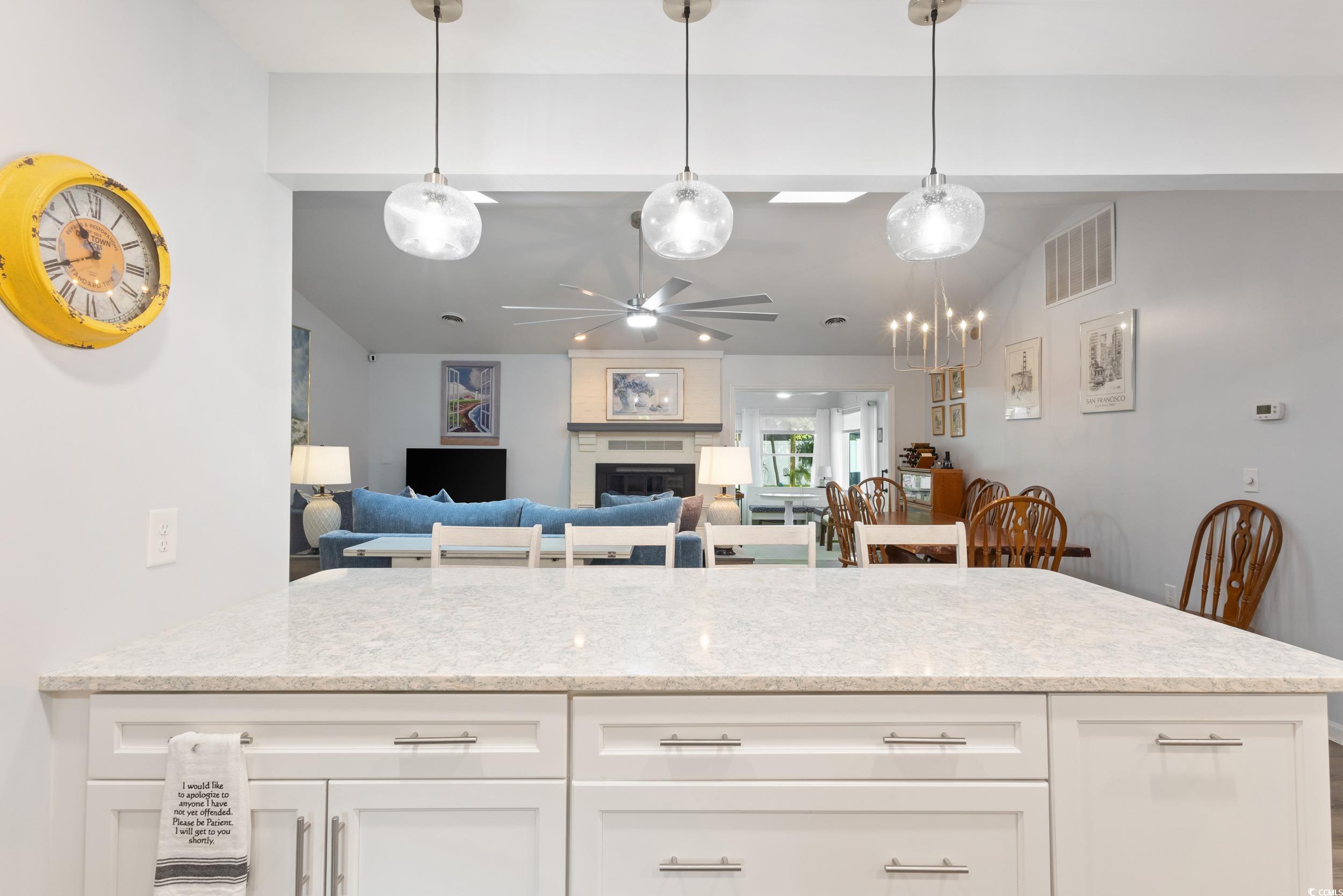 815 Tillson Road North Myrtle Beach, SC 29582 - Photo 38 of 39 Kitchen with ceiling fan, light stone counters, white cabinetry, a large fireplace, and open floor plan