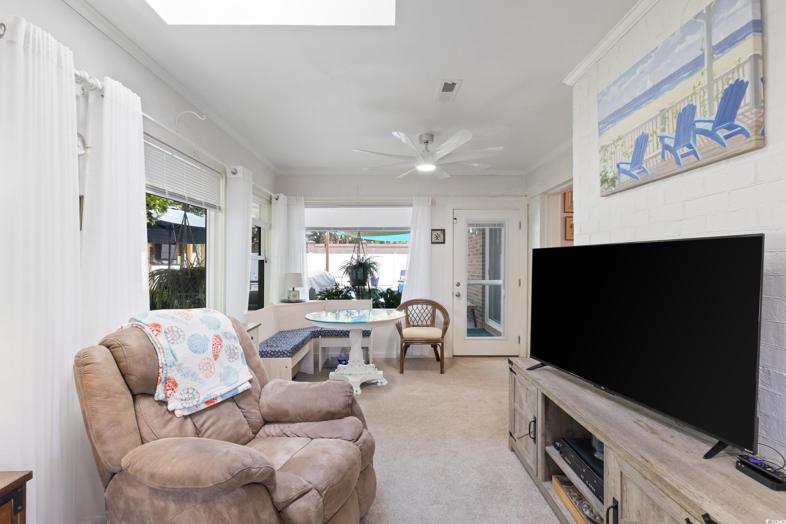 815 Tillson Road North Myrtle Beach, SC 29582 - Photo 15 of 39 Living room with crown molding, light colored carpet, ceiling fan, and a skylight