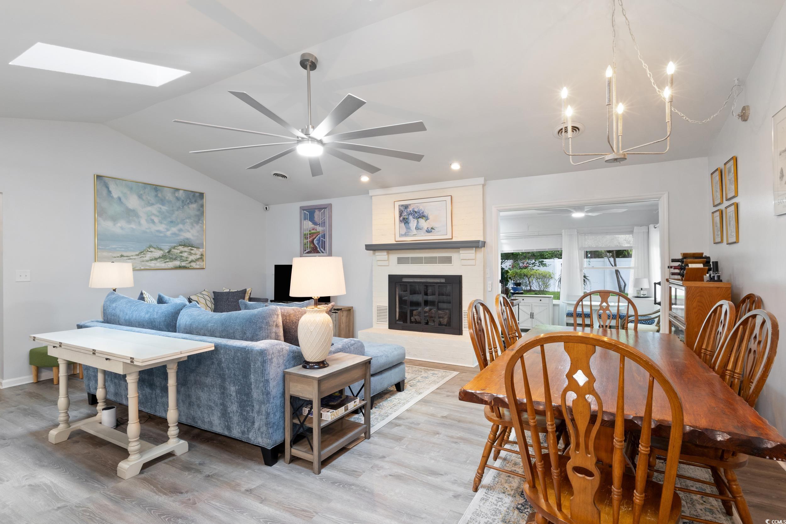 815 Tillson Road North Myrtle Beach, SC 29582 - Photo 5 of 39 Living area with lofted ceiling, light wood finished floors, ceiling fan, a fireplace, and a chandelier