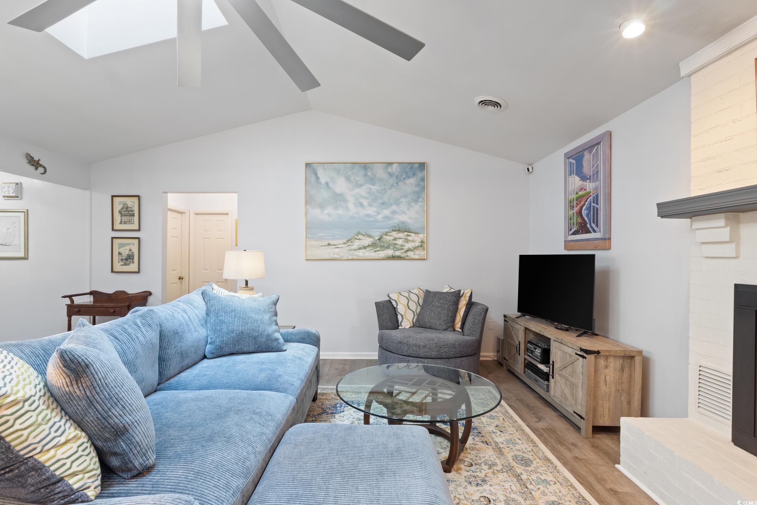 815 Tillson Road North Myrtle Beach, SC 29582 - Photo 7 of 39 Living room featuring light wood finished floors, lofted ceiling, a skylight, and a fireplace