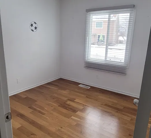 a view of a room with wooden floor and windows