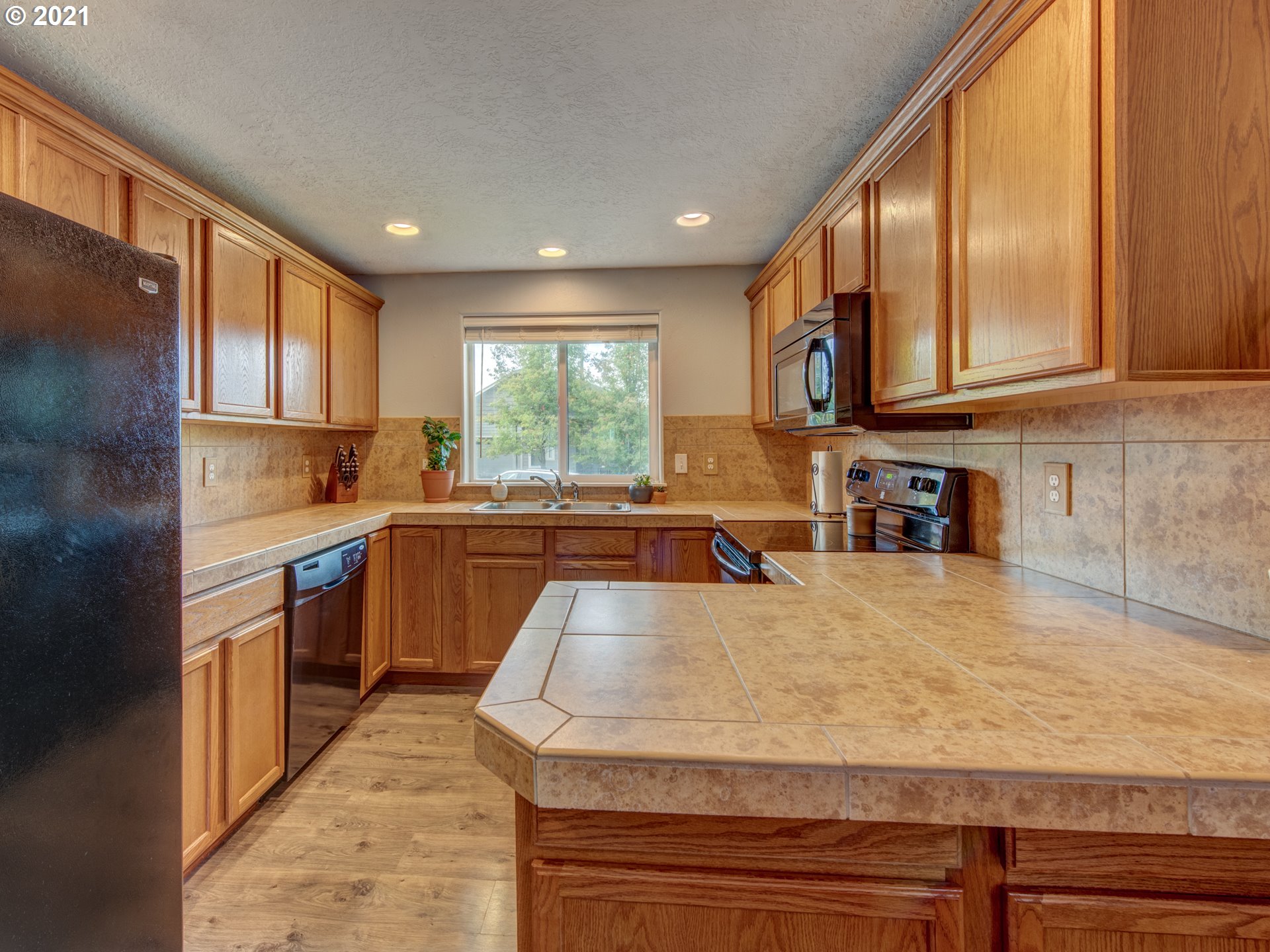 4808 Holly Street Springfield, OR 97478 - Photo 6 of 27 a kitchen with stainless steel appliances granite countertop wooden cabinets a stove a sink and a large window