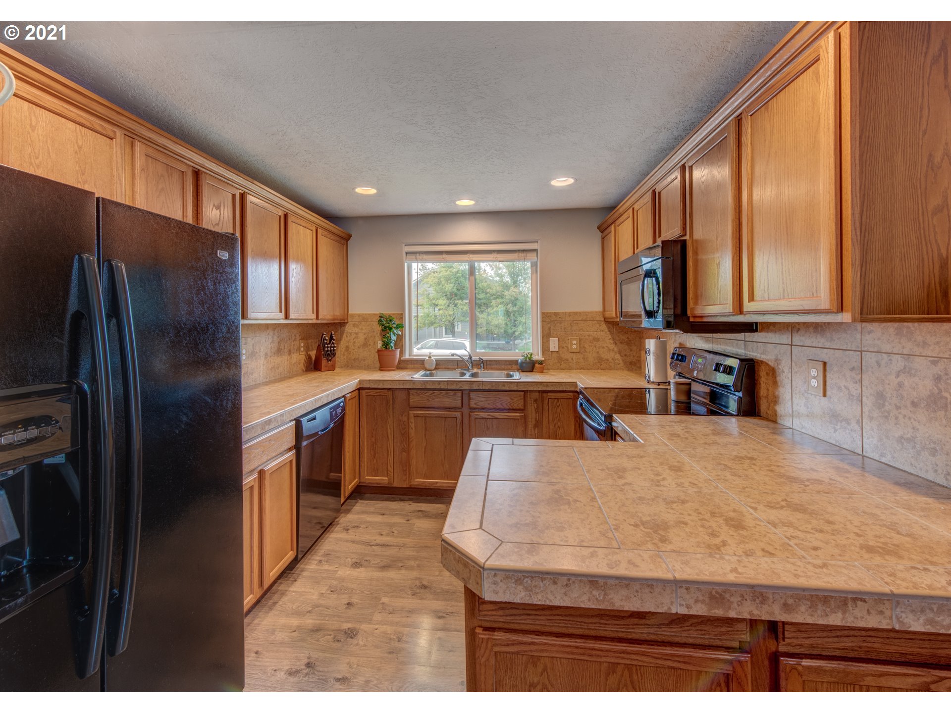 4808 Holly Street Springfield, OR 97478 - Photo 9 of 27 a kitchen with stainless steel appliances granite countertop a sink a stove and a refrigerator