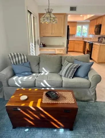 a living room with furniture and a chandelier