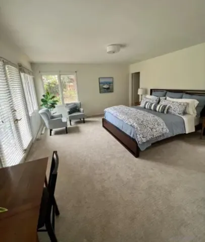 a bedroom with a bed chair and window