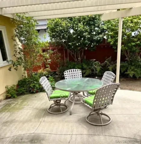 a view of a chairs and table in backyard