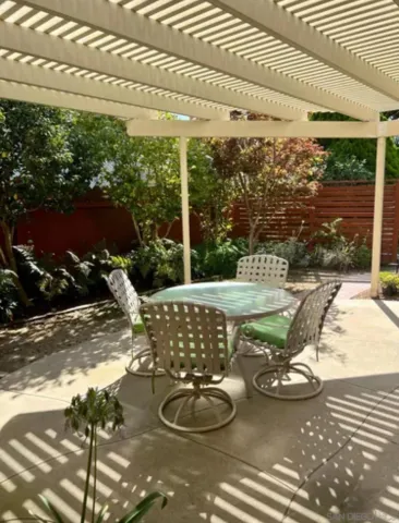 a view of a patio with table and chairs potted plants