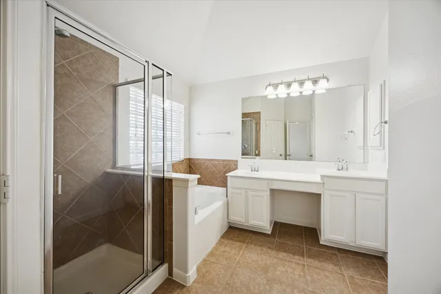 a bathroom with a double vanity sink mirror and shower