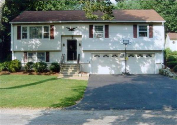 a front view of a house with a garden and plants