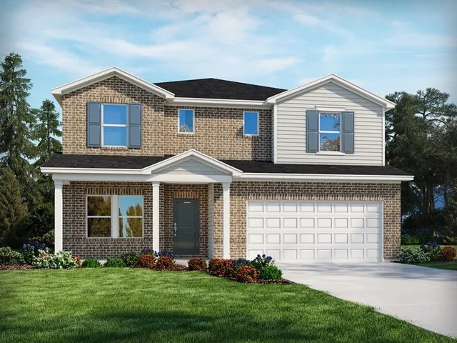 a front view of a house with a garden and yard