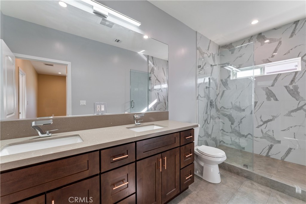 6942 Valmont Street Tujunga, CA 91042 - Photo 13 of 22 a bathroom with a double vanity sink toilet and shower