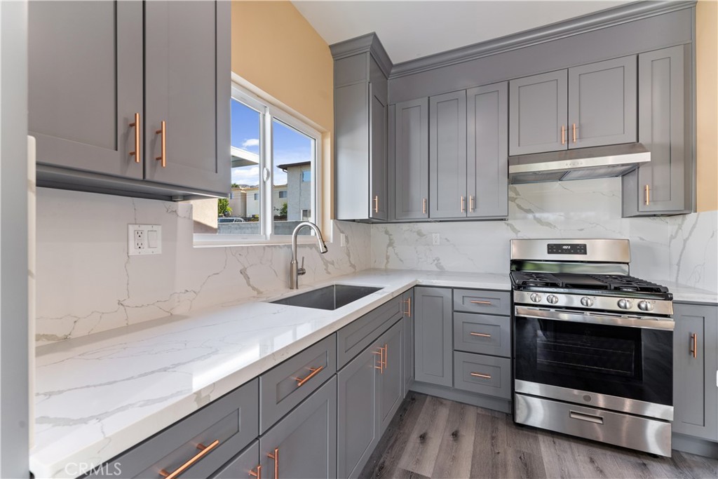 6942 Valmont Street Tujunga, CA 91042 - Photo 7 of 22 a kitchen with a sink stove and cabinets