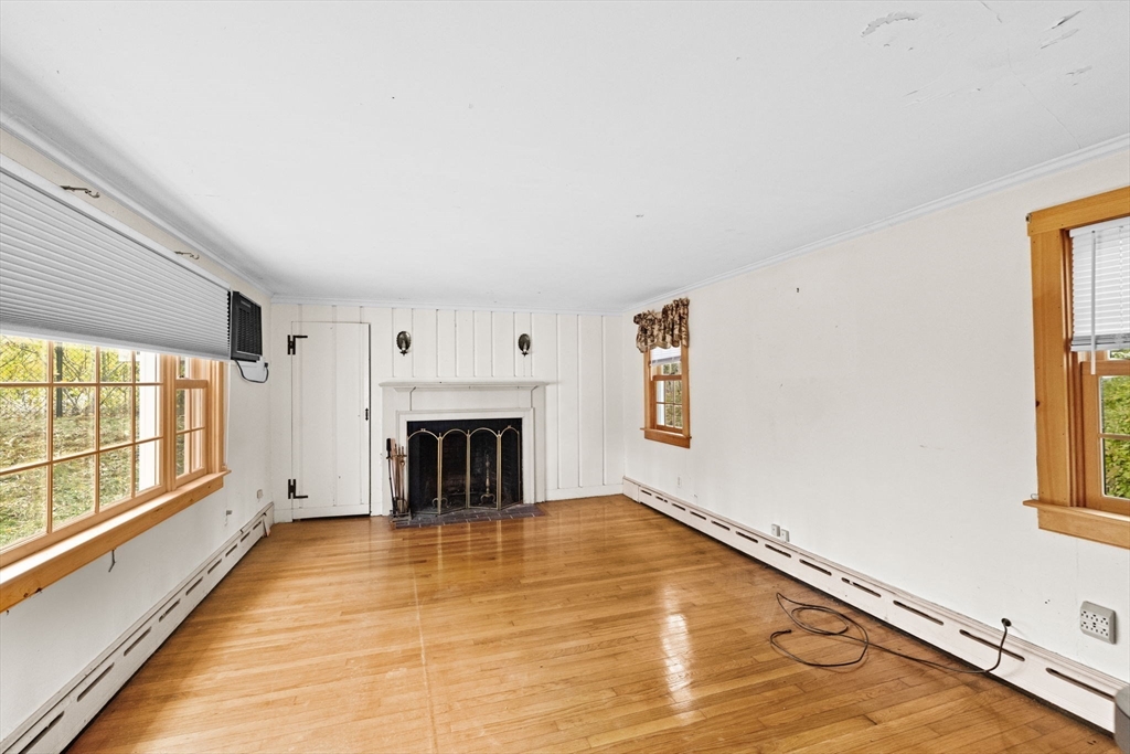 89 Ripley Road Cohasset, MA 02025 - Photo 2 of 23 a view of an empty room with a fireplace and a window