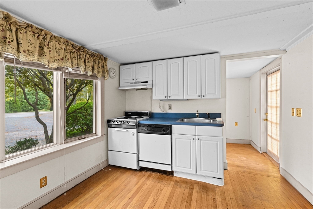 89 Ripley Road Cohasset, MA 02025 - Photo 6 of 23 a kitchen with stainless steel appliances white cabinets and wooden floors