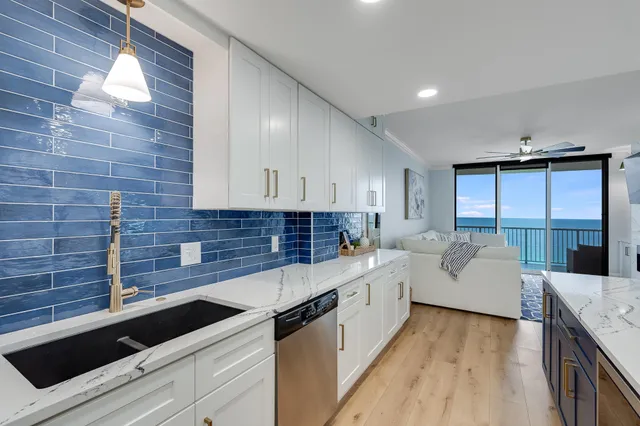a kitchen with white cabinets and sink