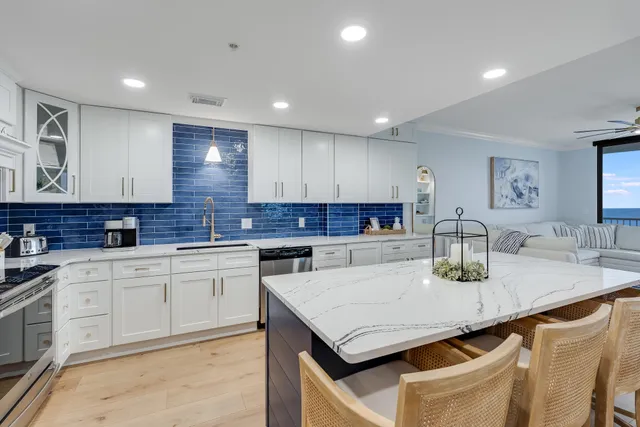 a kitchen with granite countertop white cabinets sink and stove