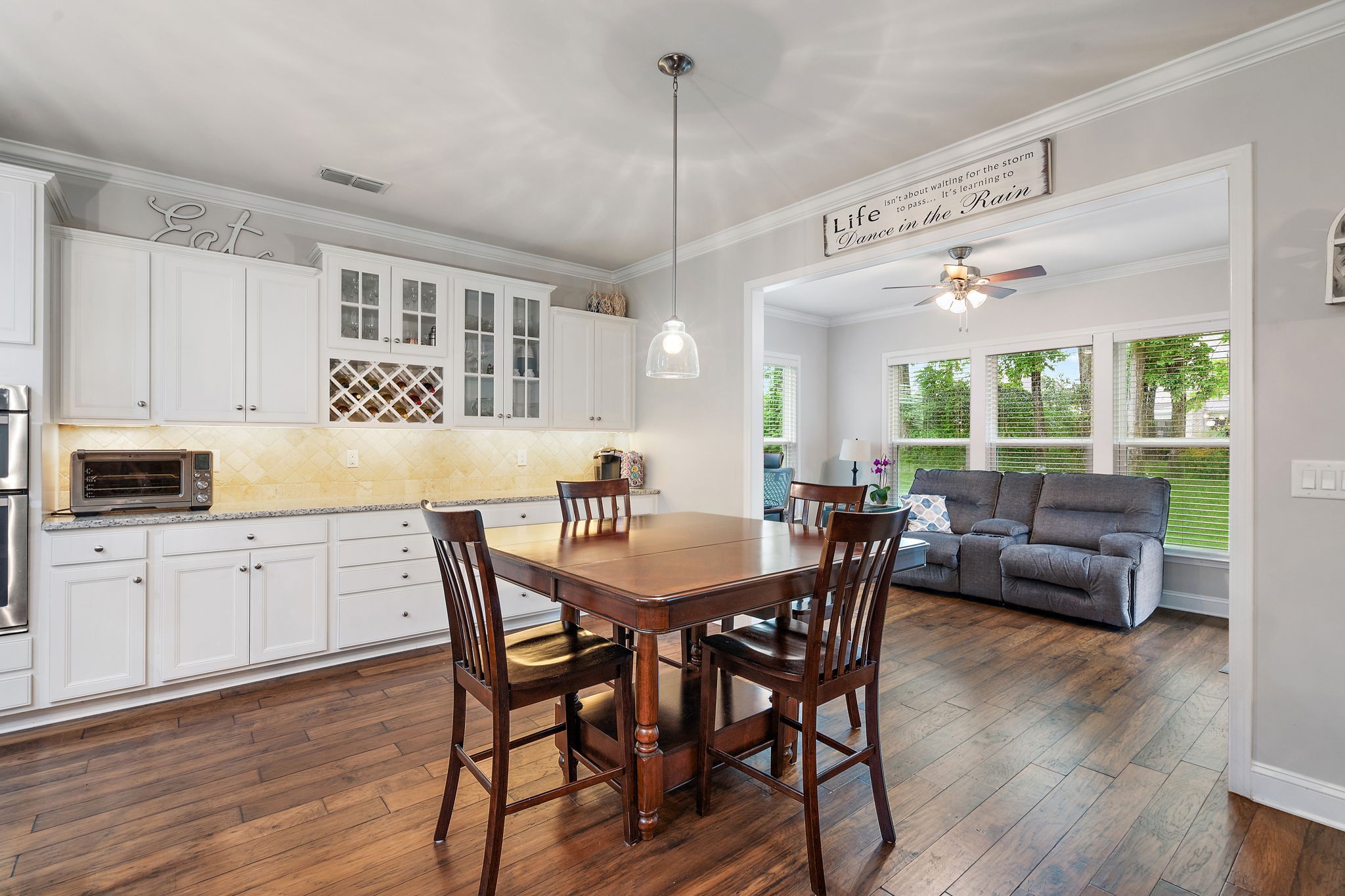 4012 Compass Pointe Court Thompson's Station, TN 37179 - Photo 15 of 54 a kitchen with granite countertop a dining table chairs and wooden floor