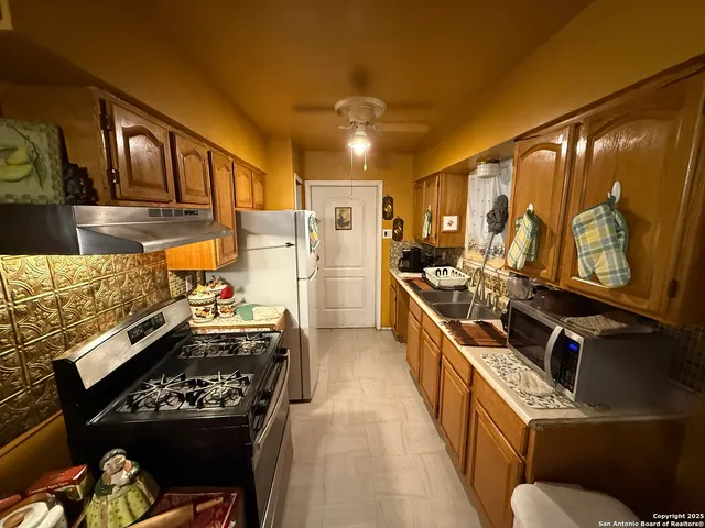 a kitchen with a stove a refrigerator and a sink