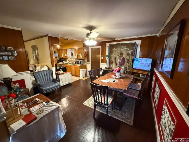 a view of a livingroom and dining room with furniture a chandelier and wooden floor