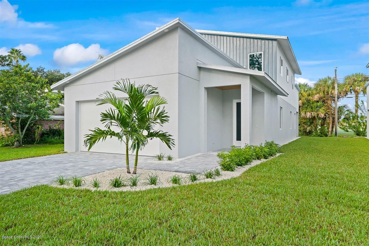 2138 Country Club Road Melbourne, FL 32901 - Photo 2 of 92 a white house with a yard potted plants and a palm tree