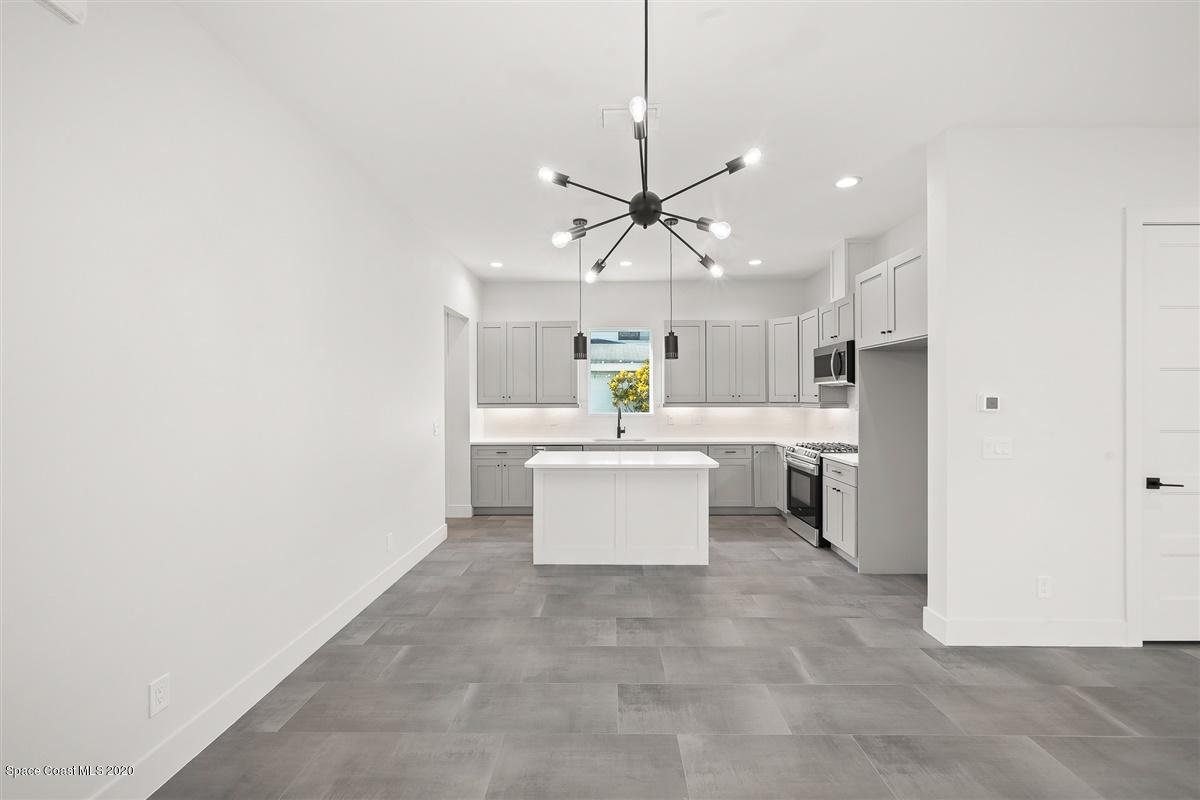 2138 Country Club Road Melbourne, FL 32901 - Photo 17 of 92 a large kitchen with a refrigerator a stove top oven a sink and dishwasher