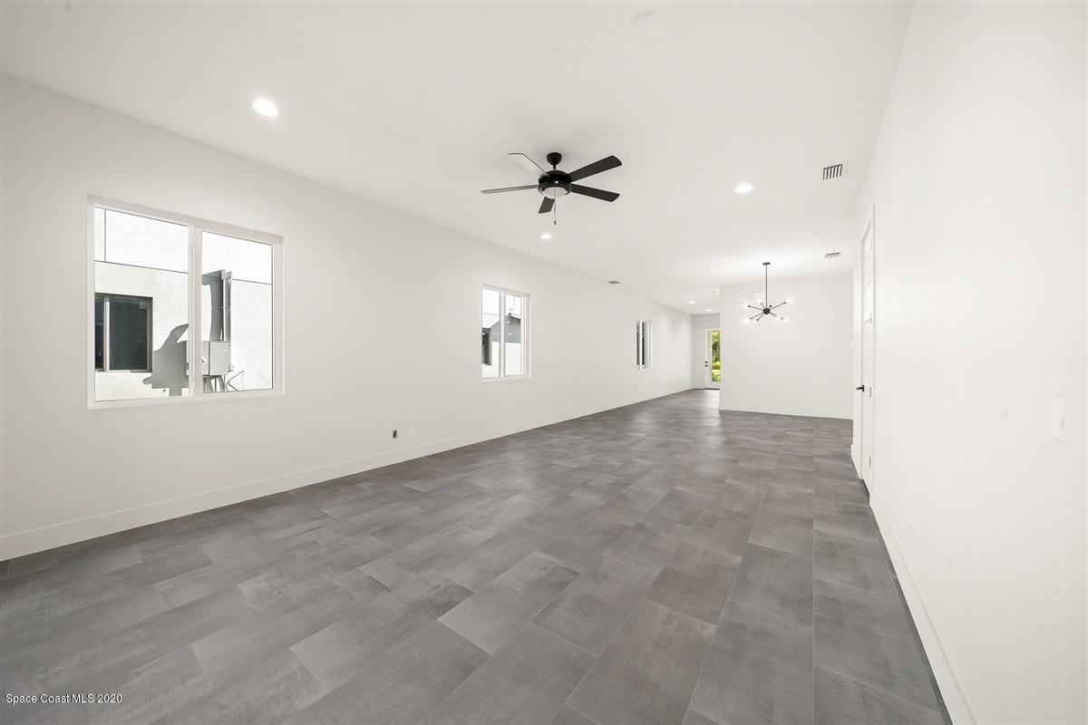 2138 Country Club Road Melbourne, FL 32901 - Photo 23 of 92 an empty room with chandelier fan and windows