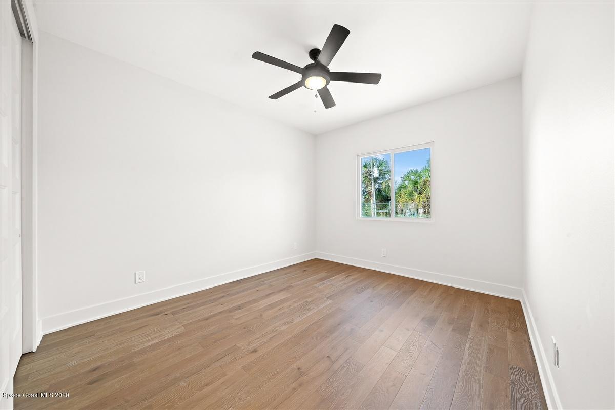 2138 Country Club Road Melbourne, FL 32901 - Photo 42 of 92 an empty room with wooden floor window and ceiling fan