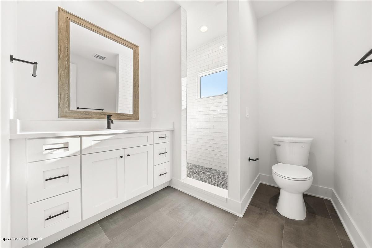 2138 Country Club Road Melbourne, FL 32901 - Photo 59 of 92 a bathroom with a toilet sink and a mirror