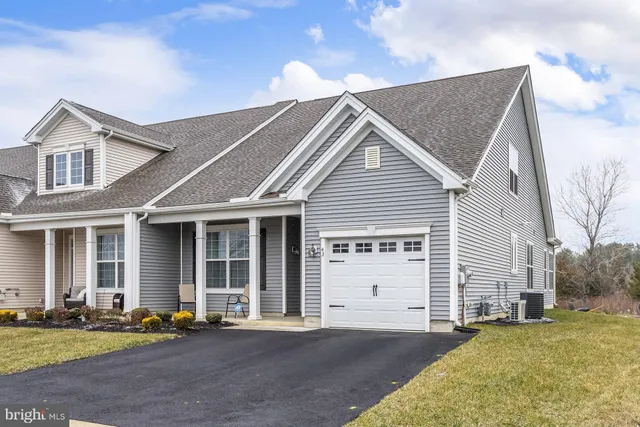 a kitchen with a refrigerator a stove a sink dishwasher a kitchen island with white cabinets and wooden floor