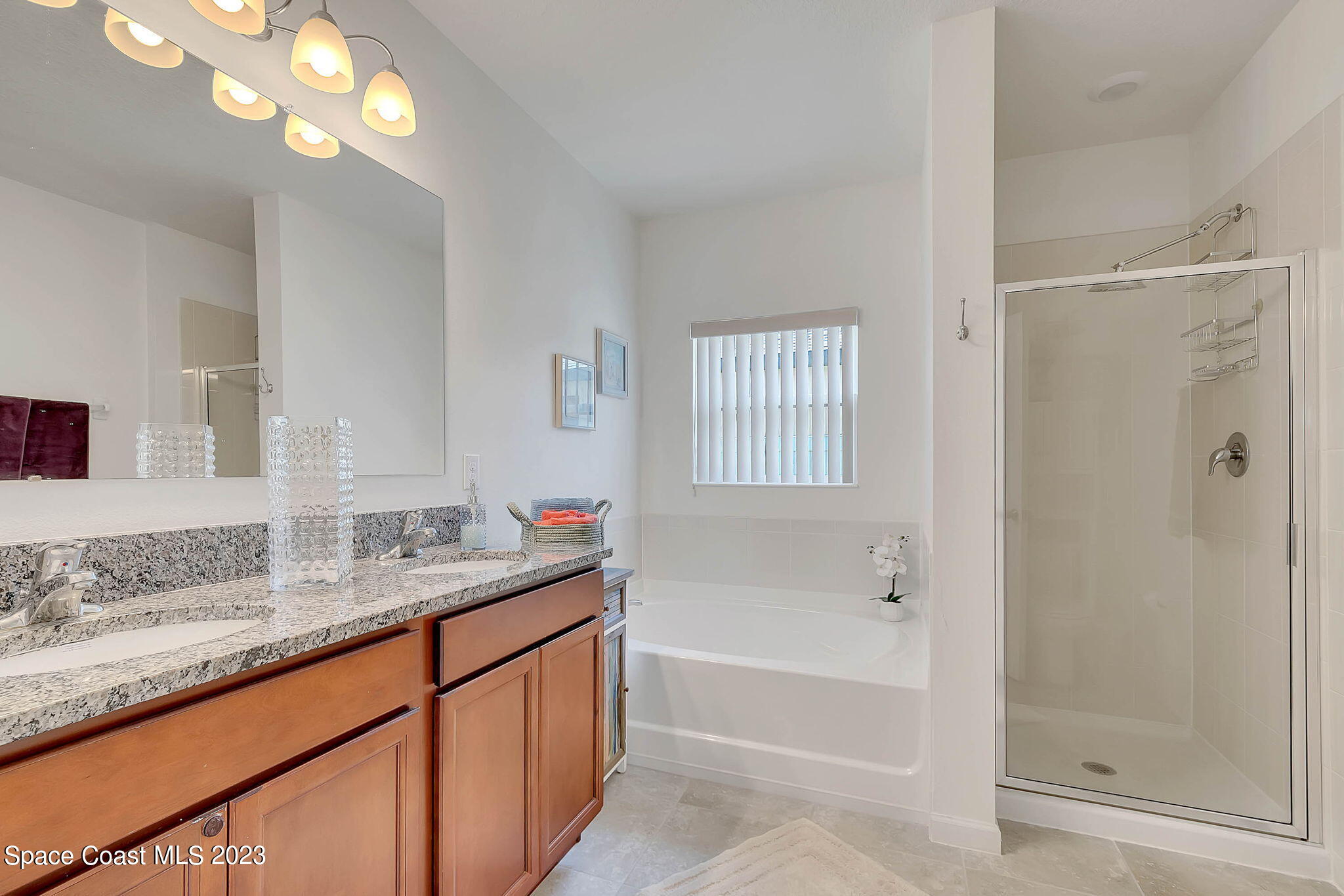3536 Whimsical Circle Rockledge, FL 32955 - Photo 22 of 40 a bathroom with a granite countertop sink a mirror and a bathtub