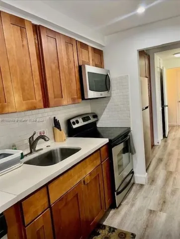 a view of a kitchen with a sink stove and refrigerator