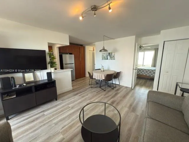a living room with couches and a large mirror with wooden floor