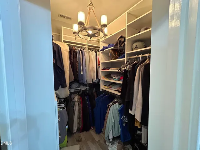 a view of walk in closet with clothes and shoes