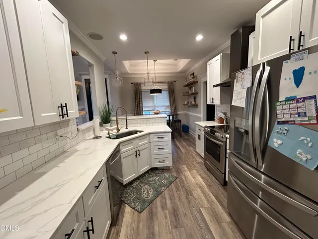 a large kitchen with stainless steel appliances sink a stove and a refrigerator